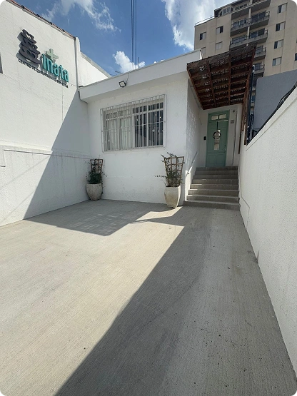 Estacionamento exclusivo da Inata Quiropraxia e Bem-Estar, com rampa de acesso e fachada clara.